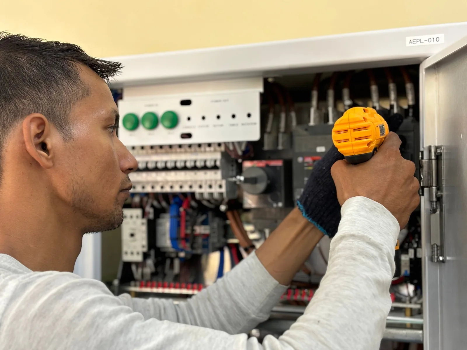 An electrician working on a commercial control panel, for subpanel installation in Hamilton