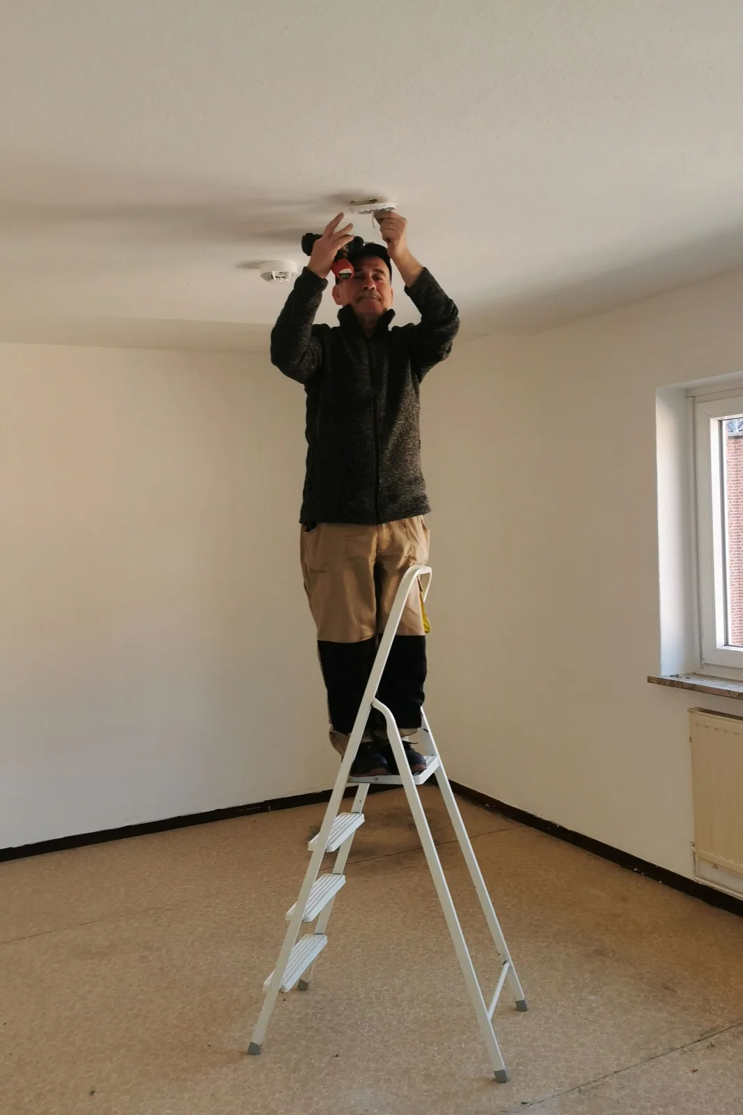 Fitting a ceiling detector from a step ladder, for ceiling fan installation in Hamilton