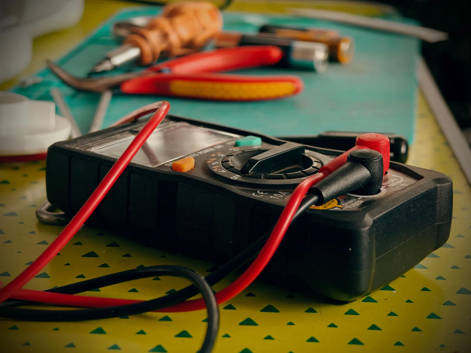 A multimeter and hand tools ready for a diagnostic visit, for electrician in Hamilton