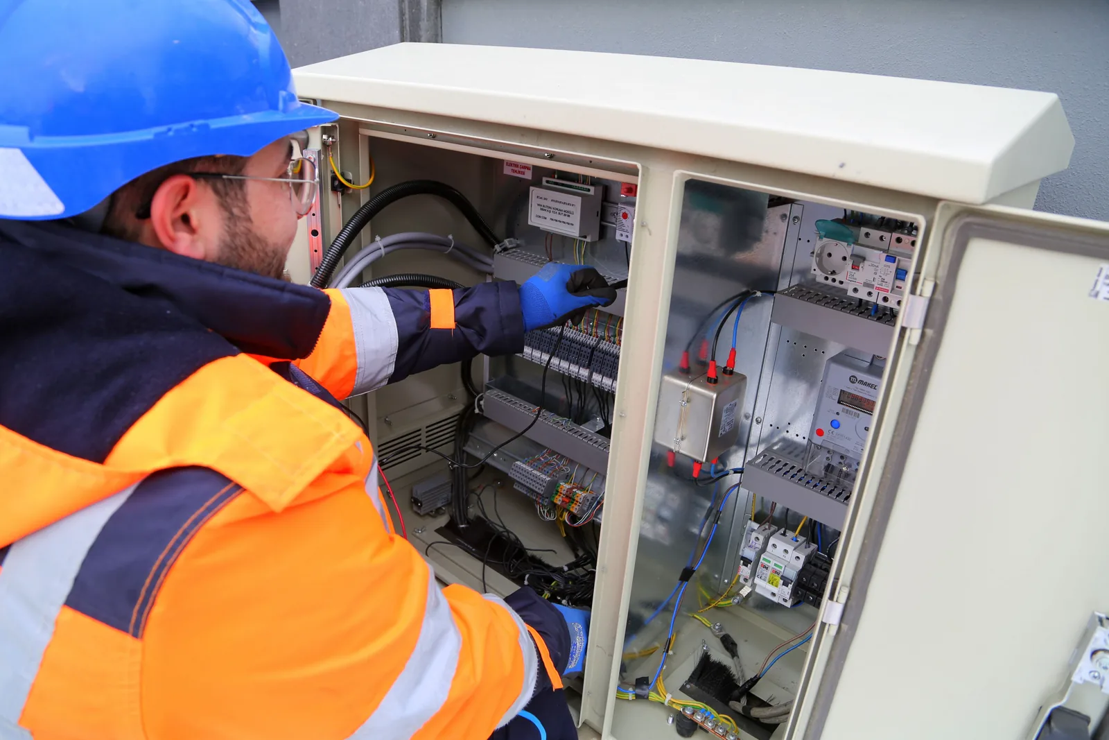 An electrician working in an outdoor service cabinet, for outdoor lighting in Hamilton